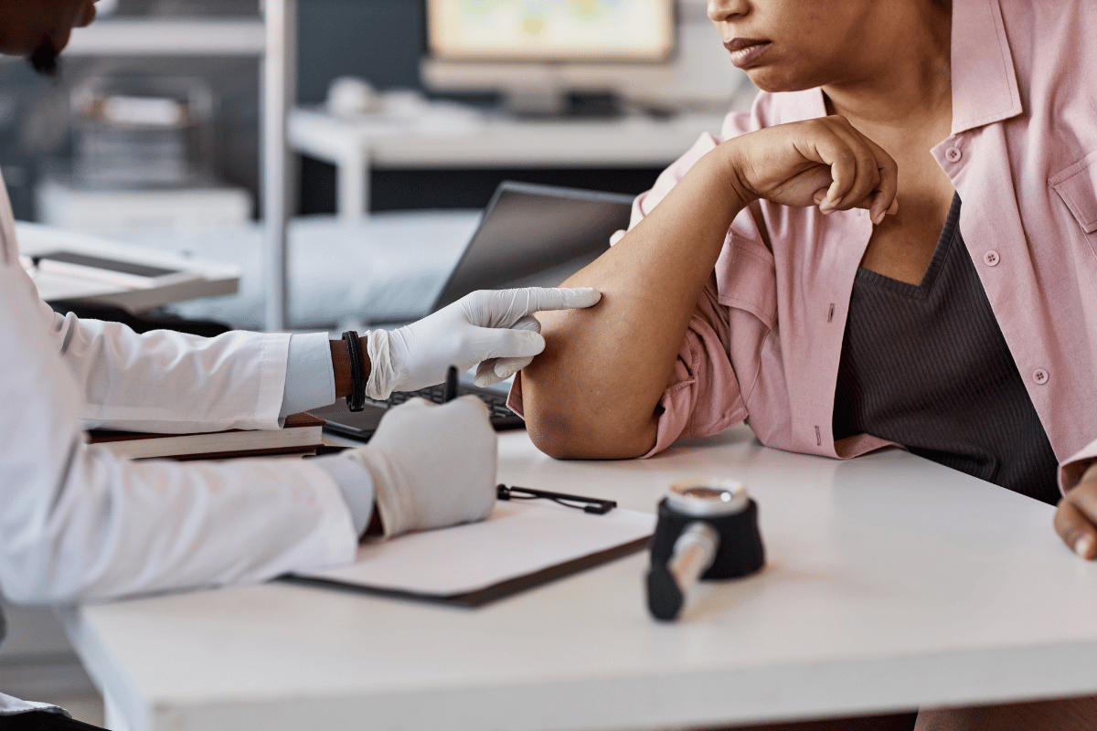 Physician looking at patient's arm